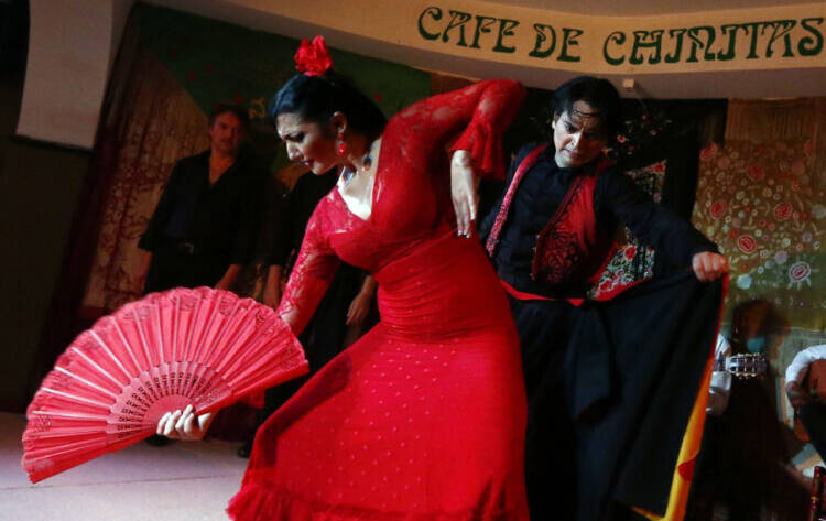 Bailaoras de flamenco con trajes rojos durante un espectáculo en un tablao de Madrid