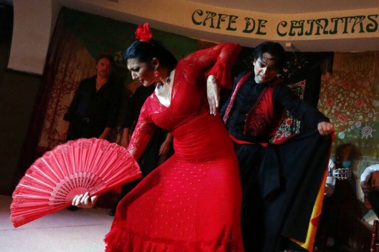 Bailaoras de flamenco con trajes rojos durante un espectáculo en un tablao de Madrid