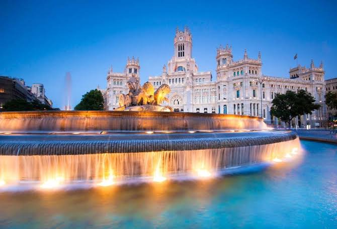 Fuente de Cibeles y el Palacio de Cibeles iluminados de noche en Madrid