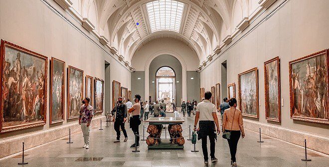 Galería de pintura de un museo de Madrid con visitantes recorriendo la sala