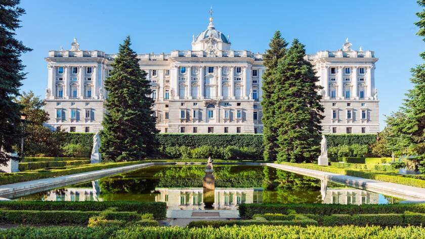 Fachada del Palacio Real de Madrid y sus jardines con estanque en un día despejado