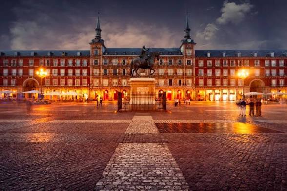 Plaza Mayor de Madrid iluminada al anochecer con la estatua ecuestre de Felipe III