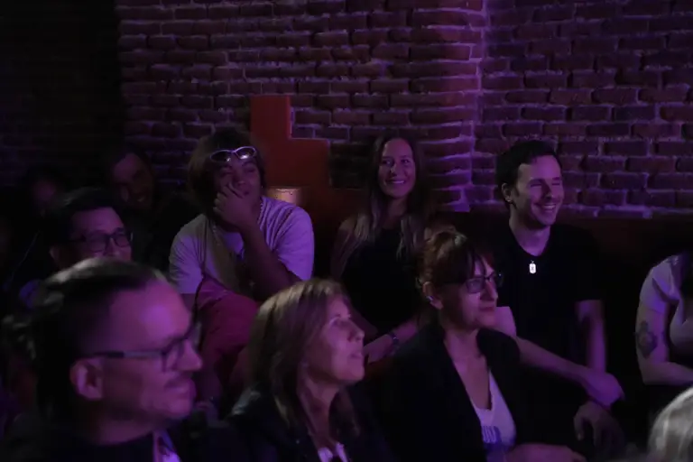 Público viendo un espectáculo junto a una pared de ladrillo