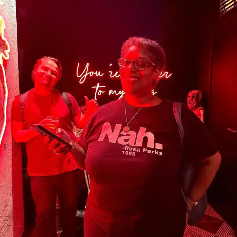 Dos mujeres charlando bajo un letrero de neón rojo antes de un espectáculo