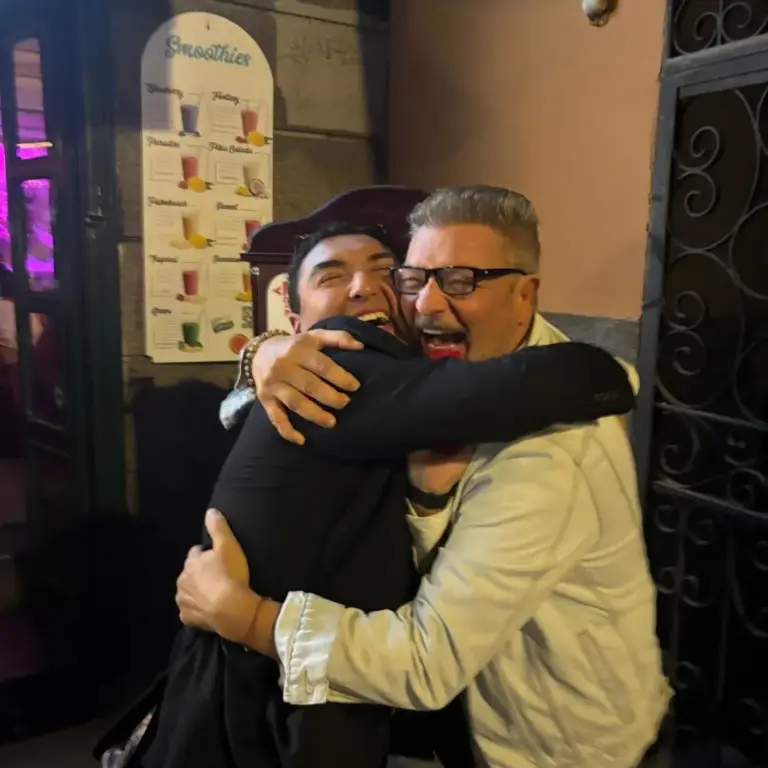 Dos artistas dándose un gran abrazo después de un espectáculo