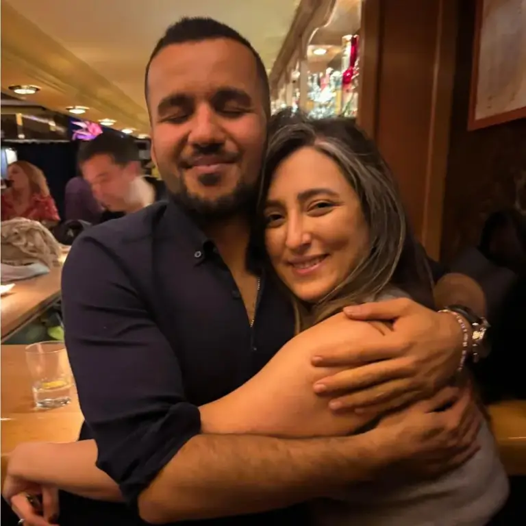 Dos amigos abrazados y sonriendo en un bar