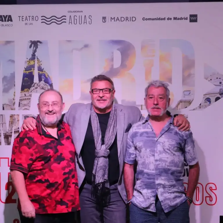 Tres hombres sonriendo delante del cartel del festival en el Teatro Amaya