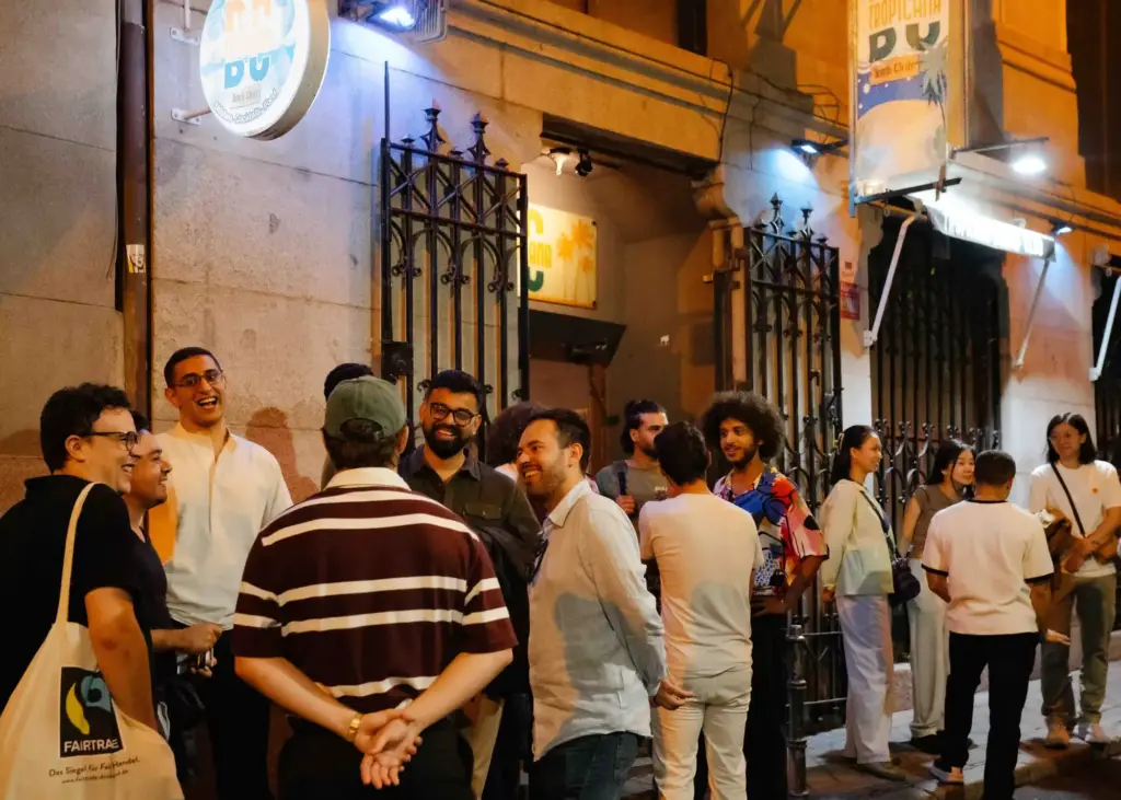 Público reunido en la calle a la puerta de una sede del festival, de noche