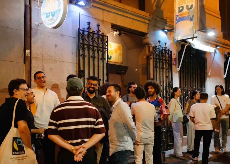 Público reunido en la calle a la puerta de una sede del festival, de noche