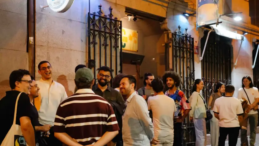 Público reunido en la calle a la puerta de una sede del festival, de noche