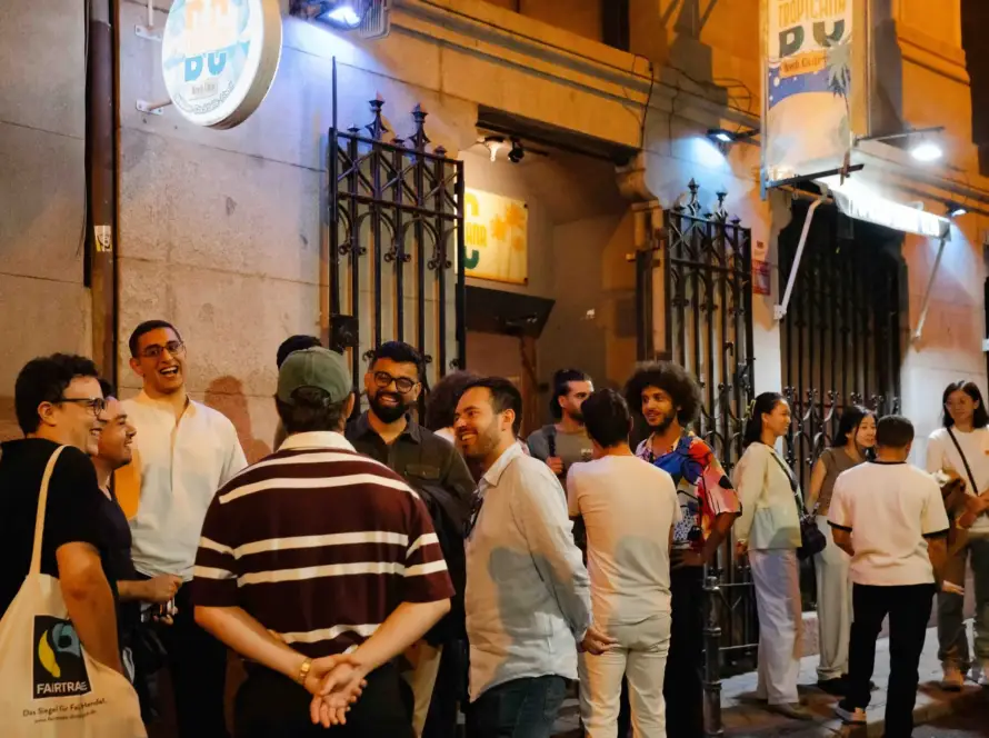 Público reunido en la calle a la puerta de una sede del festival, de noche