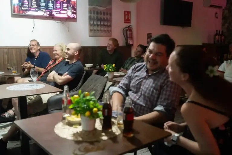Público riéndose alrededor de una mesa en Tropicana
