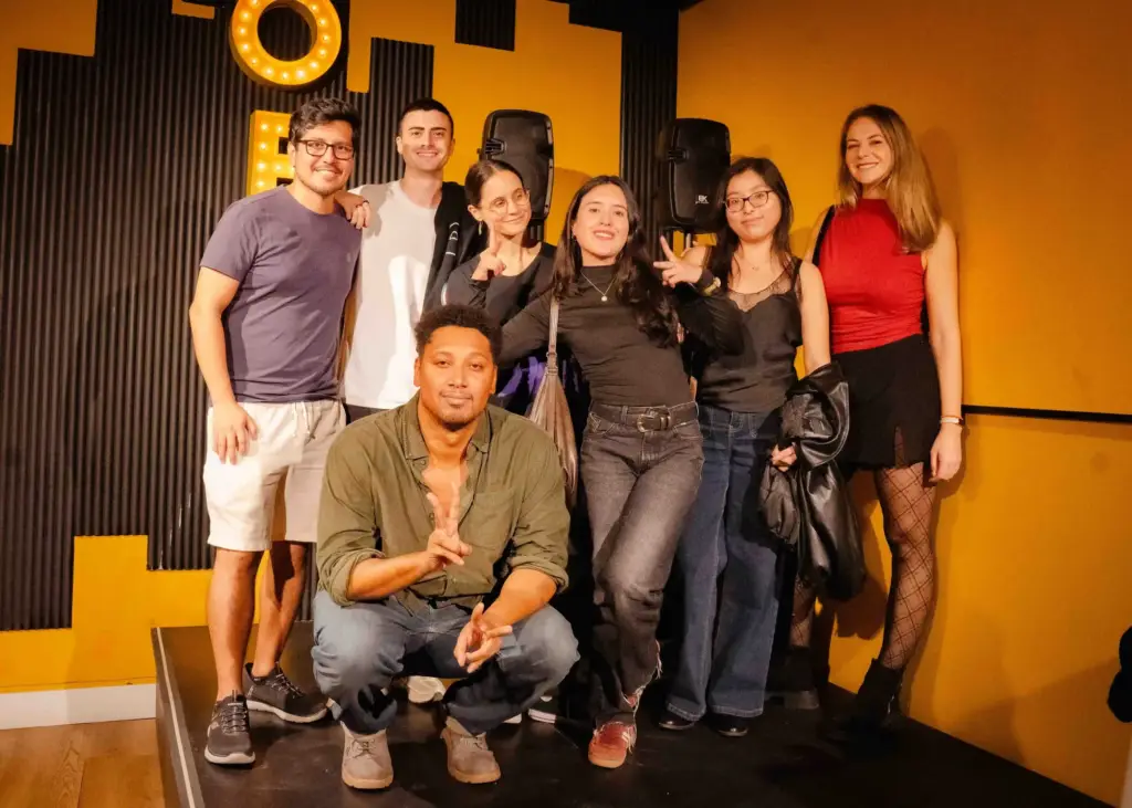 Un grupo de cómicos posando juntos en el escenario después de un espectáculo