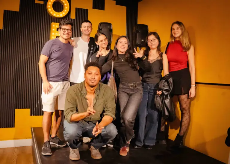 Un grupo de cómicos posando juntos en el escenario después de un espectáculo