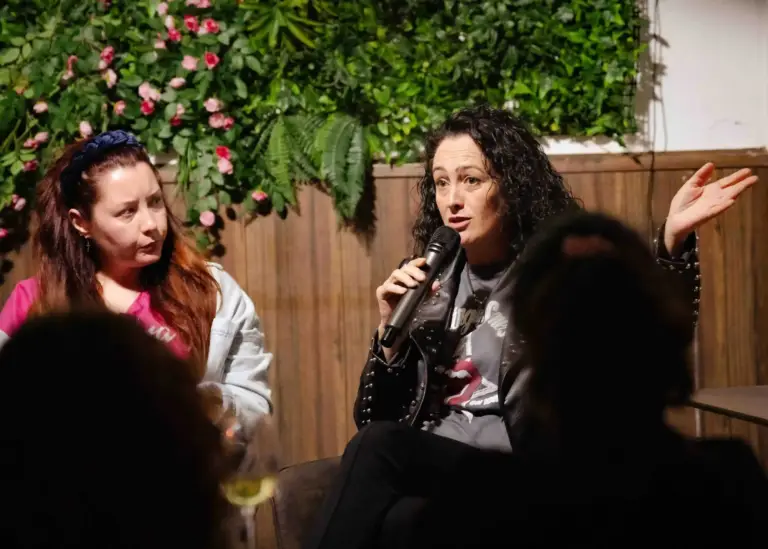 Dos artistas sentadas en el escenario de Tropicana, una hablando al micrófono